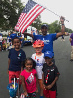 Yahye Mohamed walking with children in a parade
